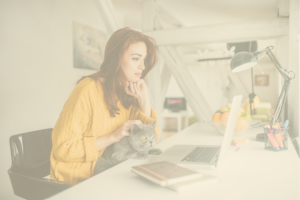 woman sitting in front of laptop with cat | How to Come Back From a Blogging Hiatus With a Bang