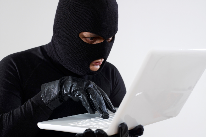 masked thief on laptop | How to Report a Stolen Instagram Photo