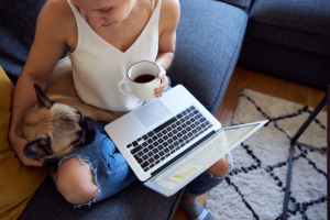 woman drinking coffee and working on laptop with dog | WordPress Bloggers: Here's How to Move from HTTP to HTTPS