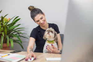 woman sitting at computer with dog | 40 Best Chrome Extensions for Small Business Owners