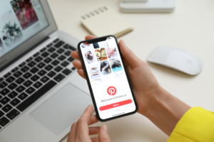 person looking at pinterest on their phone | 5 Tips To Use Pinterest for Blog Traffic