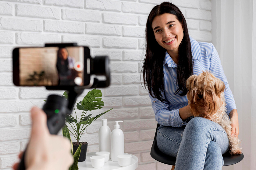 woman recording video with dog | How Can I Use YouTube for Marketing My Small Pet Business?