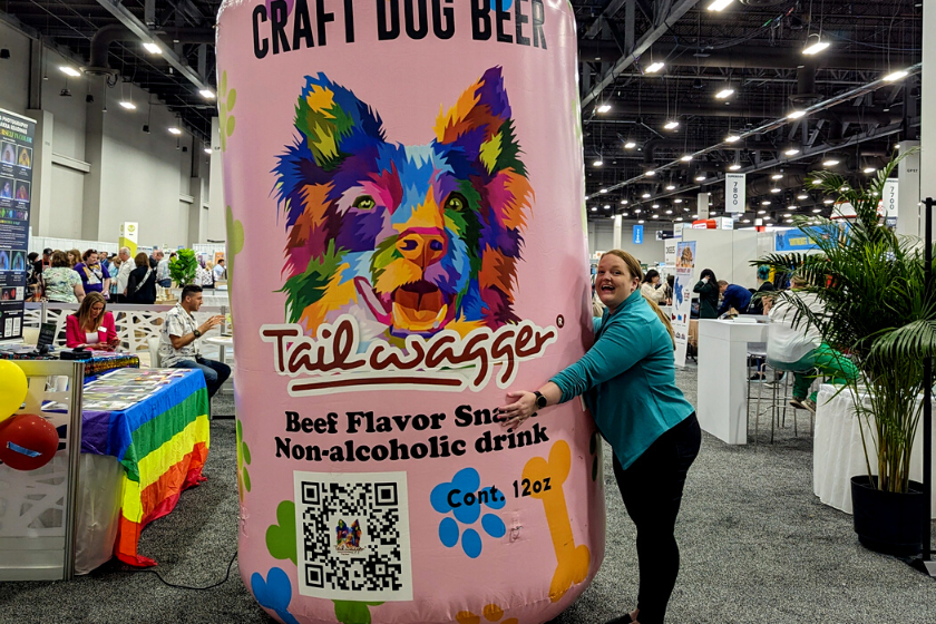 woman hugging a giant inflatable beer can | Introducing the BlogPaws Best Award Winners at SuperZoo 2023