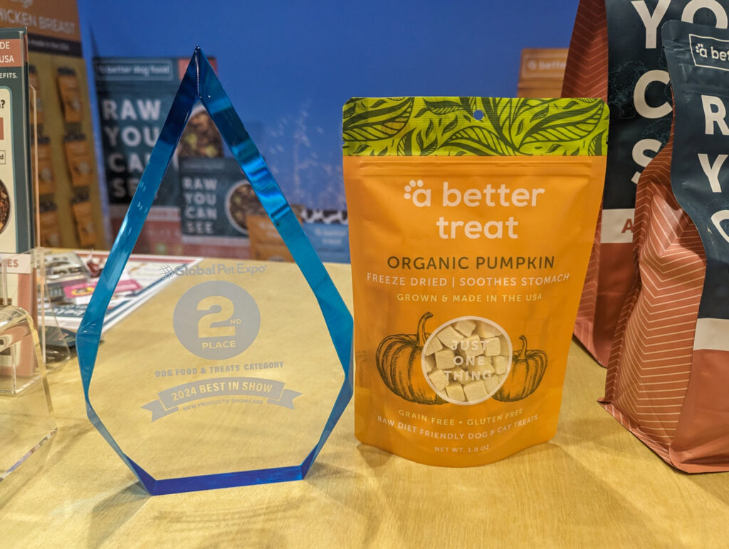 A Better Treat Organic Pumpkin bag next to clear award from the New Product Showcase (2nd place)