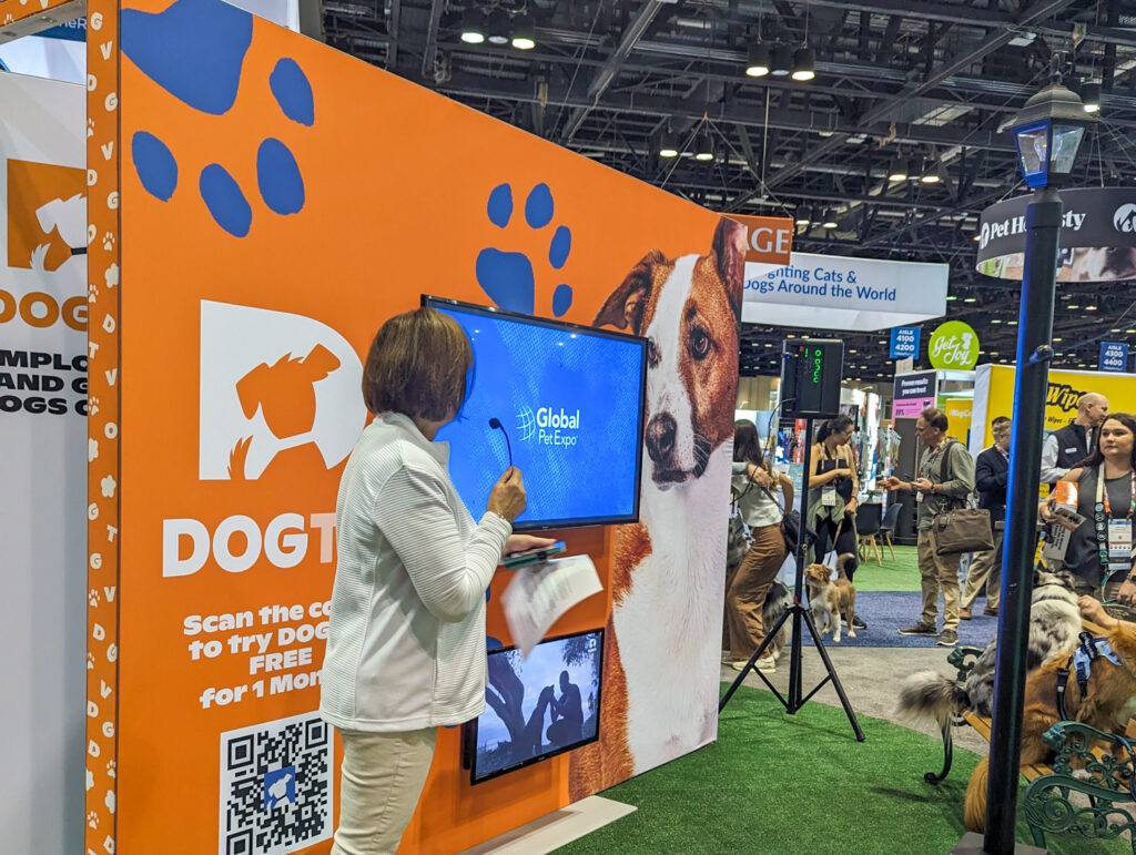 DOGTV CEO speaks in front of their booth and tv display