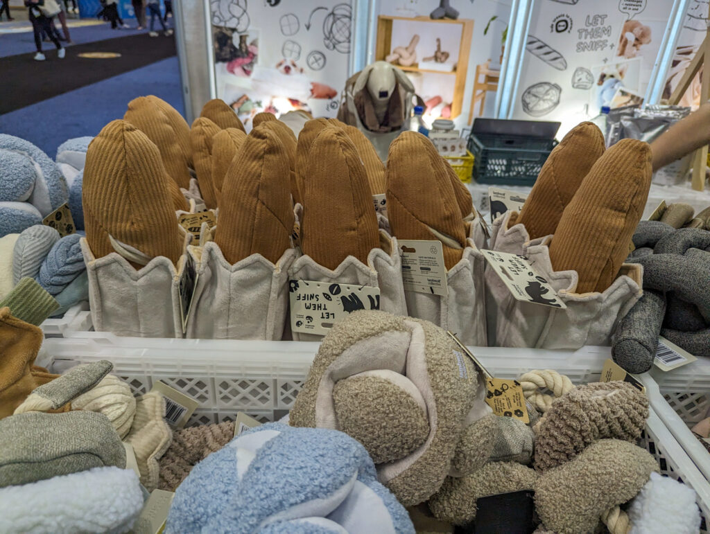 A bunch of Baguette dog toys surrounded by other plush dog toys