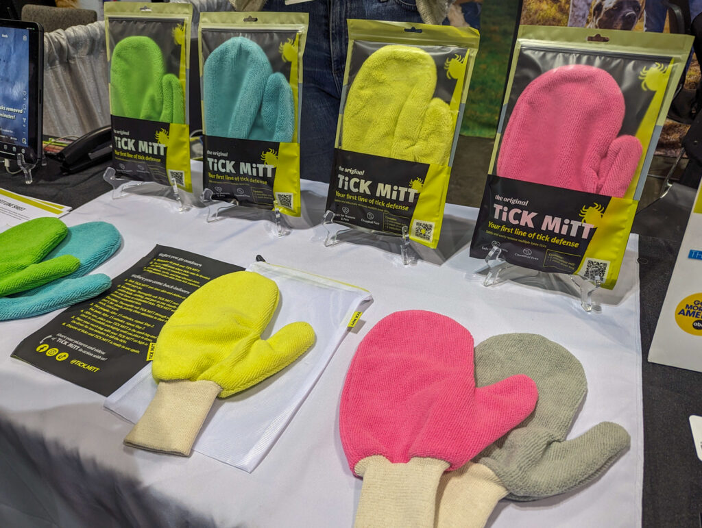 Tick Mitt in packaging and on table in green, blue, yellow, pink, and gray