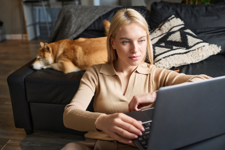 woman working on a laptop with a dog lying on the couch behind her | Google Search Documents Leak – What Does This Mean for You?